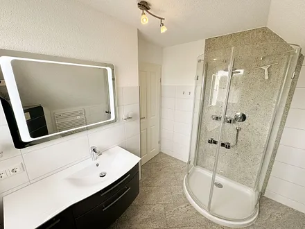 großzügiges Badezimmer mit Glasrunddusche, Handtuchtrockner, Fön, Waschbecken und WC