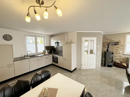 Küchenzeile mit Backofen, Ceranfeld, Kühlschrank, Mikrowelle, Geschirrspüler, Spüle und diverse Küchenutensilien