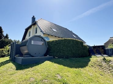 Fasssauna auf dem eingezäunten Grundstück
