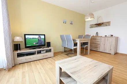 Wohnbereich mit hochwertiger Schlafcouch (1,60 m x 2,00 m, Aufbettungsmöglichkeit für 3/4 Person), Couchtisch, Leselampe, Sideboard mit Smart-TV mit Sky