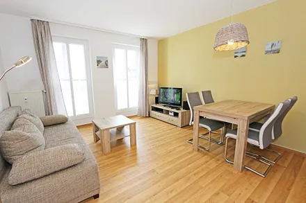 Wohnbereich mit hochwertiger Schlafcouch (1,60 m x 2,00 m, Aufbettungsmöglichkeit für 3/4 Person), Couchtisch, Leselampe, Sideboard mit Smart-TV mit Sky