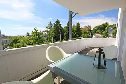 teilüberdachter, bestuhlter Südbalkon mit Meerblick in Richtung Südstrand und der Halbinsel Mönchgut 