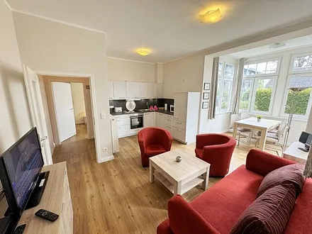 offener Wohnbereich mit Sofa, Sessel, Couchtisch und Sideboard, Flachbild-TV, Blu-Ray-Player und Mini-Stereo-Anlage mit USB-Anschluss