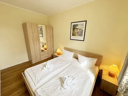 Schlafzimmer mit Doppelbett (1,80 m x 2,00 m), großen Kleiderschrank und Nachttischablagen