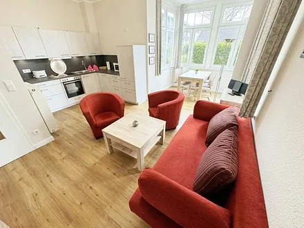 offener Wohnbereich mit Sofa, Sessel, Couchtisch und Sideboard, Flachbild-TV, Blu-Ray-Player und Mini-Stereo-Anlage mit USB-Anschluss