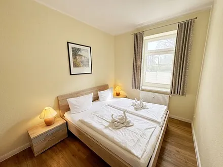 Schlafzimmer mit Doppelbett (1,80 m x 2,00 m), großen Kleiderschrank und Nachttischablagen