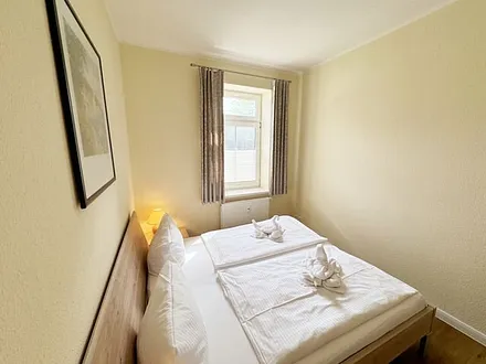 Schlafzimmer mit Doppelbett (1,80 m x 2,00 m), großen Kleiderschrank und Nachttischablagen