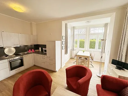 offener Wohnbereich mit Sofa, Sessel, Couchtisch und Sideboard, Flachbild-TV, Blu-Ray-Player und Mini-Stereo-Anlage mit USB-Anschluss