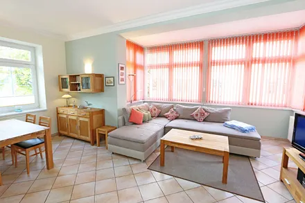 Wohnbereich mit Couch (Ausziehfunktion zum Doppelbett (1,60 m x 2,00 m), Kleiderschrank, Sessel, Couchtisch, kleinem Beistelltisch, Flachbild-TV, DVD-Player sowie Mini-Stereo-Anlage mit USB-Anschluss