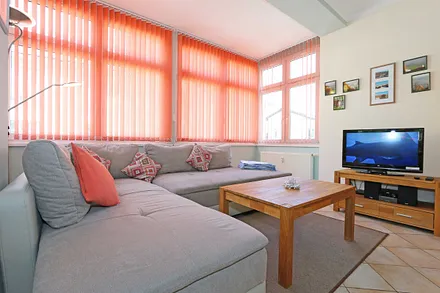 Wohnbereich mit Couch (Ausziehfunktion zum Doppelbett (1,60 m x 2,00 m), Kleiderschrank, Sessel, Couchtisch, kleinem Beistelltisch, Flachbild-TV, DVD-Player sowie Mini-Stereo-Anlage mit USB-Anschluss