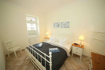 Schlafzimmer mit Doppelbett (1,80 m x 2,00 m), Nachttischablagen, geräumige Kommode und Wandspiegel