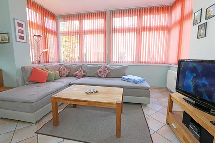 Wohnbereich mit Couch (Ausziehfunktion zum Doppelbett (1,60 m x 2,00 m), Kleiderschrank, Sessel, Couchtisch, kleinem Beistelltisch, Flachbild-TV, DVD-Player sowie Mini-Stereo-Anlage mit USB-Anschluss