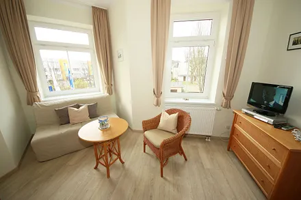 Schlafzimmer mit Doppelbett (1,80 m x 2,00 m), großem Kleiderschrank, Nachttischablagen, Kommode mit Smart-TV und komfortabler Leseecke mit kleiner Bücherauswahl