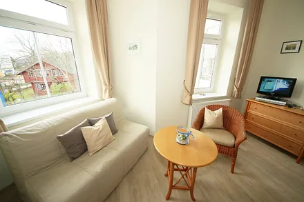 Schlafzimmer mit Doppelbett (1,80 m x 2,00 m), großem Kleiderschrank, Nachttischablagen, Kommode mit Smart-TV und komfortabler Leseecke mit kleiner Bücherauswahl