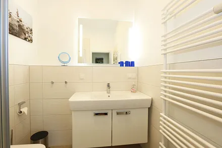 Badezimmer mit ebenerdiger Dusche, Waschplatz, WC, Kosmetikspiegel und Fön