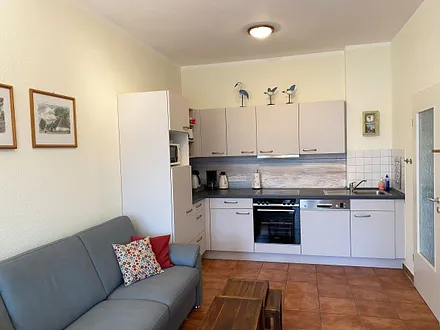 offener Wohnbereich mit Sofa, Sessel, Couchtisch, Sideboard, Leselampe, Smart-TV, DVD-Player sowie Mini-Stereo-Anlage mit USB-Anschluss und DAB-Radio