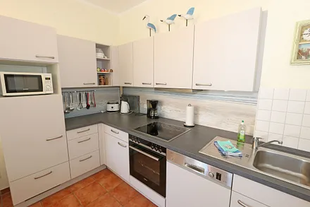 integrierte Küchenzeile mit Cerankochfeld, Backofen, Geschirrspüler, Kühlschrank, Gefrierfach, Mikrowelle, Kaffeemaschine, Wasserkocher, Toaster und diversen Küchenutensilien