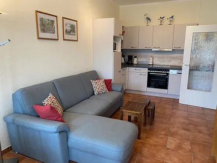 offener Wohnbereich mit Sofa, Sessel, Couchtisch, Sideboard, Leselampe, Smart-TV, DVD-Player sowie Mini-Stereo-Anlage mit USB-Anschluss und DAB-Radio