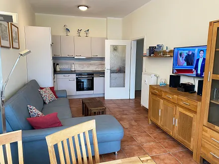 offener Wohnbereich mit Sofa, Sessel, Couchtisch, Sideboard, Leselampe, Smart-TV, DVD-Player sowie Mini-Stereo-Anlage mit USB-Anschluss und DAB-Radio