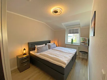 Schlafzimmer mit Boxspringbett (1,80 m x 2,00 m), Nachtischablagen, Kleiderschrank und Smart-TV 