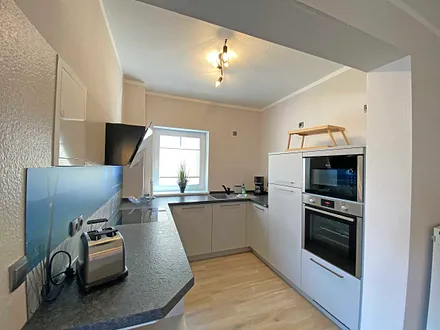 moderne Küchenzeile mit Geschirrspüler, Toaster, Wasserkocher, Kaffeemaschine, 4 Zonen-Kochfeld, Backofen, integrierte Mikrowelle, Kühl-Gefrierkombination und hochwertigen Granitarbeitsflächen