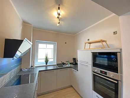 moderne Küchenzeile mit Geschirrspüler, Toaster, Wasserkocher, Kaffeemaschine, 4 Zonen-Kochfeld, Backofen, integrierte Mikrowelle, Kühl-Gefrierkombination und hochwertigen Granitarbeitsflächen