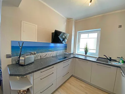 moderne Küchenzeile mit Geschirrspüler, Toaster, Wasserkocher, Kaffeemaschine, 4 Zonen-Kochfeld, Backofen, integrierte Mikrowelle, Kühl-Gefrierkombination und hochwertigen Granitarbeitsflächen