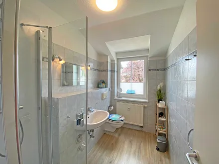 Tageslicht-Bad verfügt über eine Dusche mit flachem Einstieg, WC, Fön, Kosmetikspiegel und Waschtisch