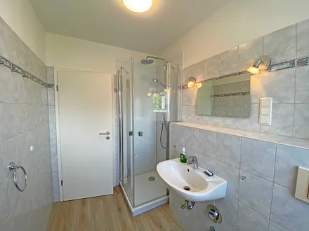 Tageslicht-Bad verfügt über eine Dusche mit flachem Einstieg, WC, Fön, Kosmetikspiegel und Waschtisch