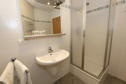 Badezimmer mit Dusche (flacher Einstieg), WC, Waschtisch und Fön 