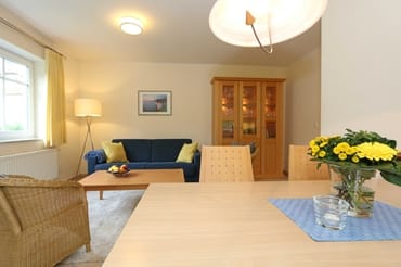 Wohnbereich mit Sofa, Sessel, Couchtisch, Vitrine, Leselampe, Flatscreen-TV mit DVD-Player, Stereoanlage mit CD und eine kleine Auswahl an Gesellschaftsspielen