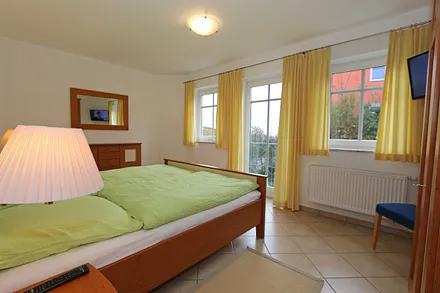 Schlafzimmer mit Doppelbett (1,80 m x 2,00 m), 2 Nachtschränken, Flachbild-TV und Kleiderschrank - von hier aus haben Sie etwas Blick auf die Ostsee