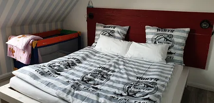 Schlafzimmer mit Babyreisebett