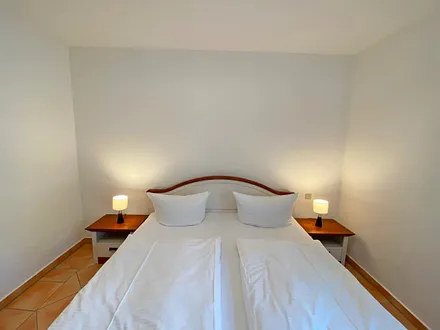 Schlafzimmer mit Doppelbett (1,80 m x 2,00 m), Nachttischablagen, großer Kleiderschrank und Außenrollos