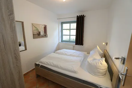 Schlafzimmer mit Doppelbett (1,60 m x 2,00 m), Kleiderschrank und Außenrollos