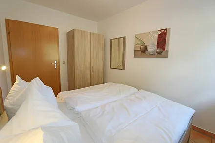 Schlafzimmer mit Doppelbett (1,60 m x 2,00 m), Kleiderschrank und Außenrollos