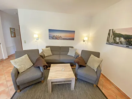 moderner Wohnbereich mit gemütlicher Polsterecke, Couchtisch, Leselampe, Flachbild-TV, DVD-Player und eine Mini-Stereo-Anlage