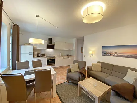 moderner Wohnbereich mit gemütlicher Polsterecke, Couchtisch, Leselampe, Flachbild-TV, DVD-Player und eine Mini-Stereo-Anlage