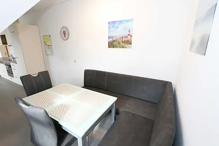 Essbereich mit zwei Stühle, Glastisch sowie eine Sitzecke