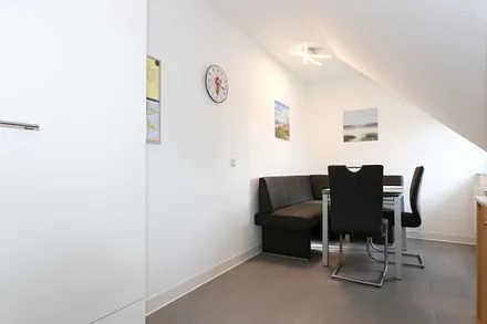 Essbereich mit zwei Stühle, Glastisch sowie eine Sitzecke