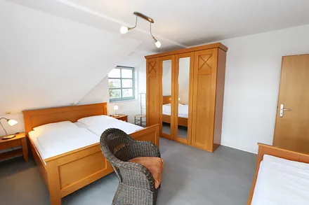 Schlafzimmer mit Doppelbett (1,80 m x 2,00 m /HG 2), 2 Nachtschränken, 1 Einzelbett sowie großer Kleiderschrank mit Ganzkörperspiegel