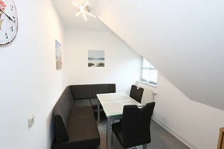 Essbereich mit zwei Stühle, Glastisch sowie eine Sitzecke