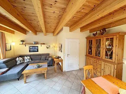 Wohnbereich mit Couchecke (Aufbettung für 5. Person, 1,30 m x 1,90 m), Couchtisch, Leselampe, Bücherregal mit kleiner Buchauswahl, Smart-TV, DVD-Player und kleiner Musikanlage