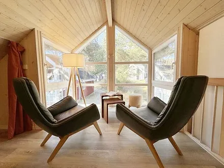 lichtdurchflutete Galerie mit bodentiefer Fensterfront, gemütliche Sitzgruppe (mit Blick in den Kiefernwald) und ein franzöisches Bett (1,40 m x 2,00 m unter einer Dachschräge)