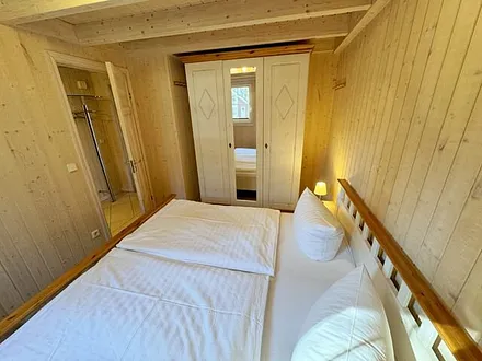 Schlafzimmer mit Doppelbett (1,80 m x 1,90 m), verstellbare Lattenroste, Nachttischablage und geräumigem Kleiderschrank