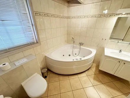 vollausgestattetes Badezimmer mit Dusche, Whirlpool-Badewanne, WC, Waschplatz, Fön, Kosmetikspiegel, Waschmaschine und Sauna