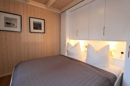 Schlafzimmer mit Doppelbett (1,60 m x 2,00 m), Nachttischablagen und Kleiderschrank
