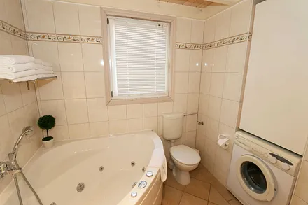 großzügiges Bad mit Dusche, Whirlpool, Sauna, Fußbodenheizung, Waschplatz, WC, Kosmetikspiegel, Fön und Waschmaschine