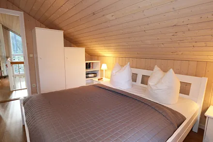 Schlafzimmer mit einem Doppelbett (1,80 m x 2,00 m),  Nachttischablagen und Kleiderschrank