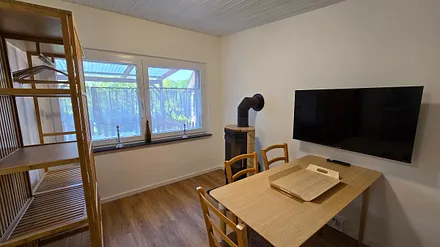 Wohnzimmer mit Etagenbett und Kaminofen